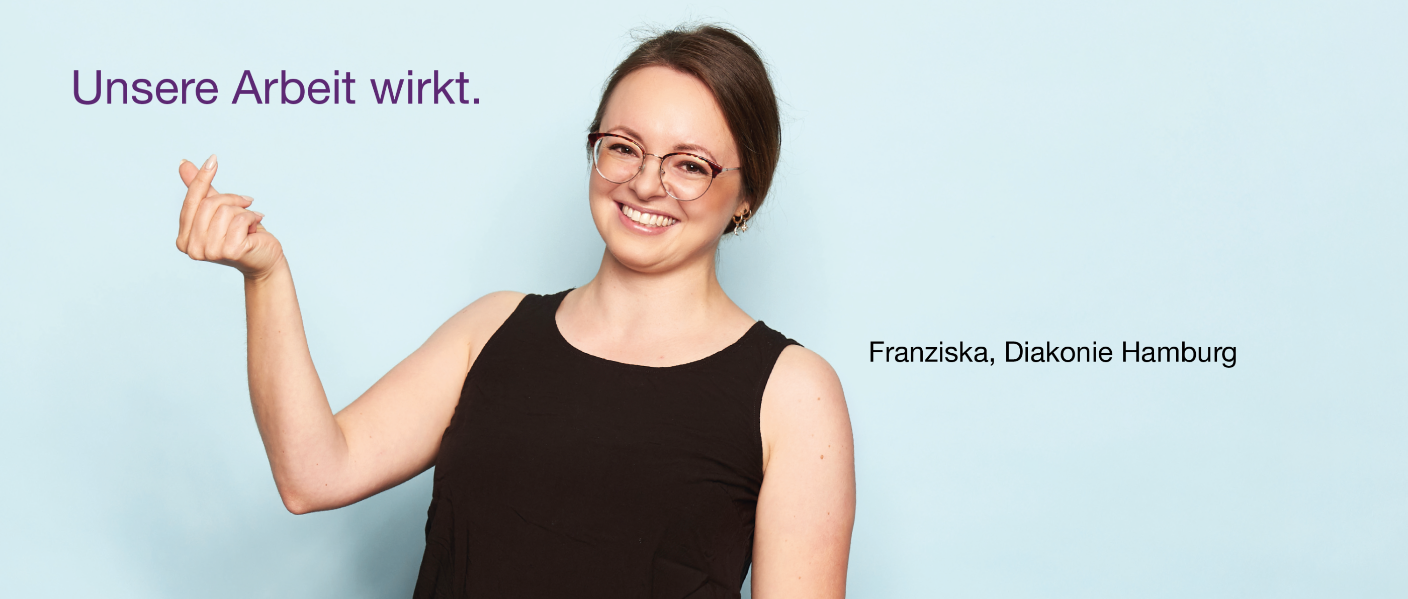 Person mit Brille und schwarzem ärmellosen Oberteil lächelt vor hellblauem Hintergrund. Oben links steht „Unsere Arbeit wirkt.“ in lila Schrift, unten rechts: „Sonja, Diakonie Hamburg“.