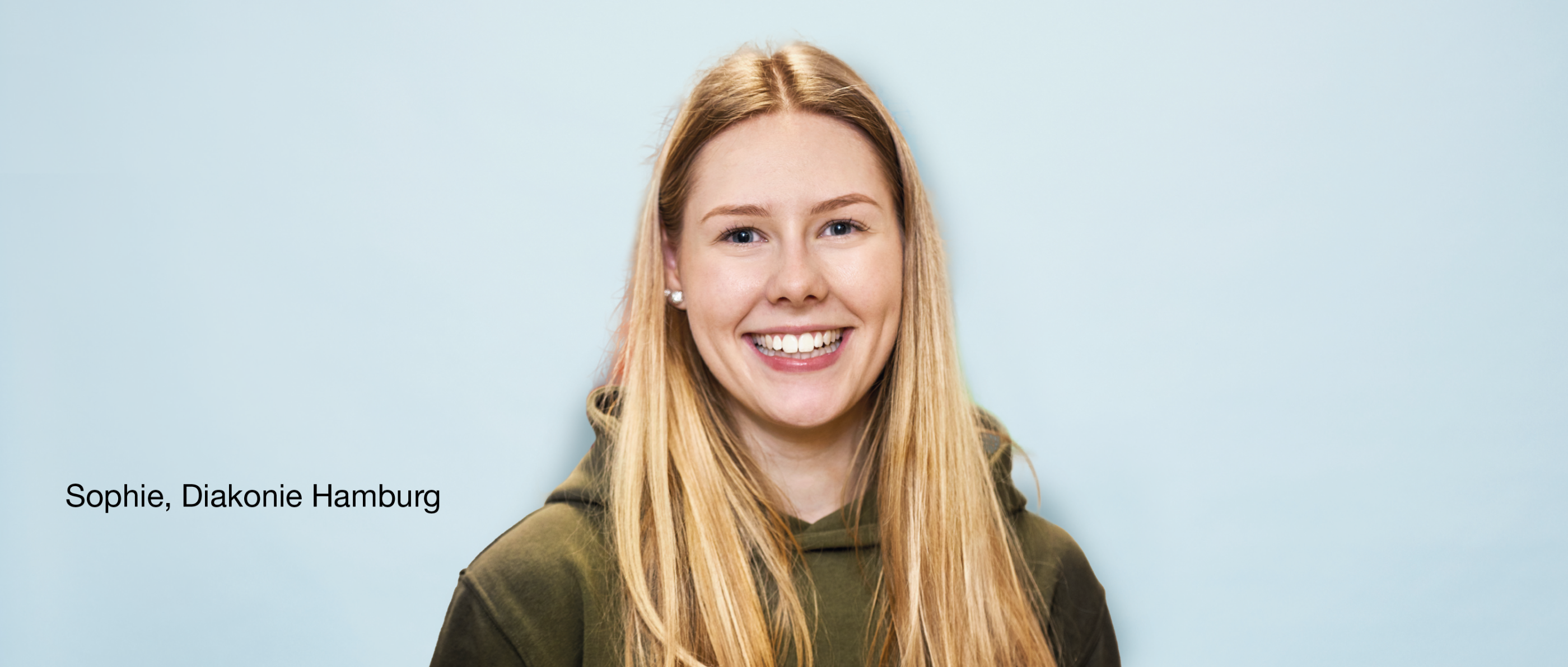 Person mit langen Haaren lächelt vor hellblauem Hintergrund. Text links: 'Sophie, Diakonie Hamburg'.